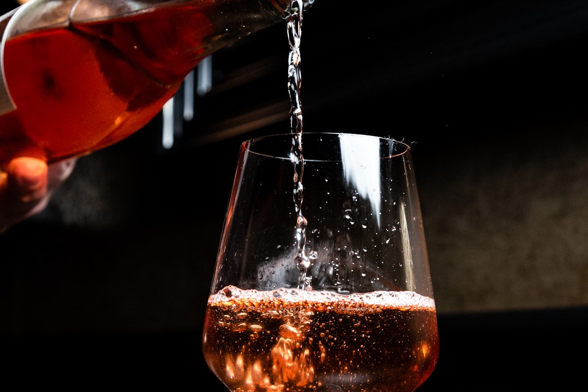 Roséwein wird elegant in ein Glas eingeschenkt
