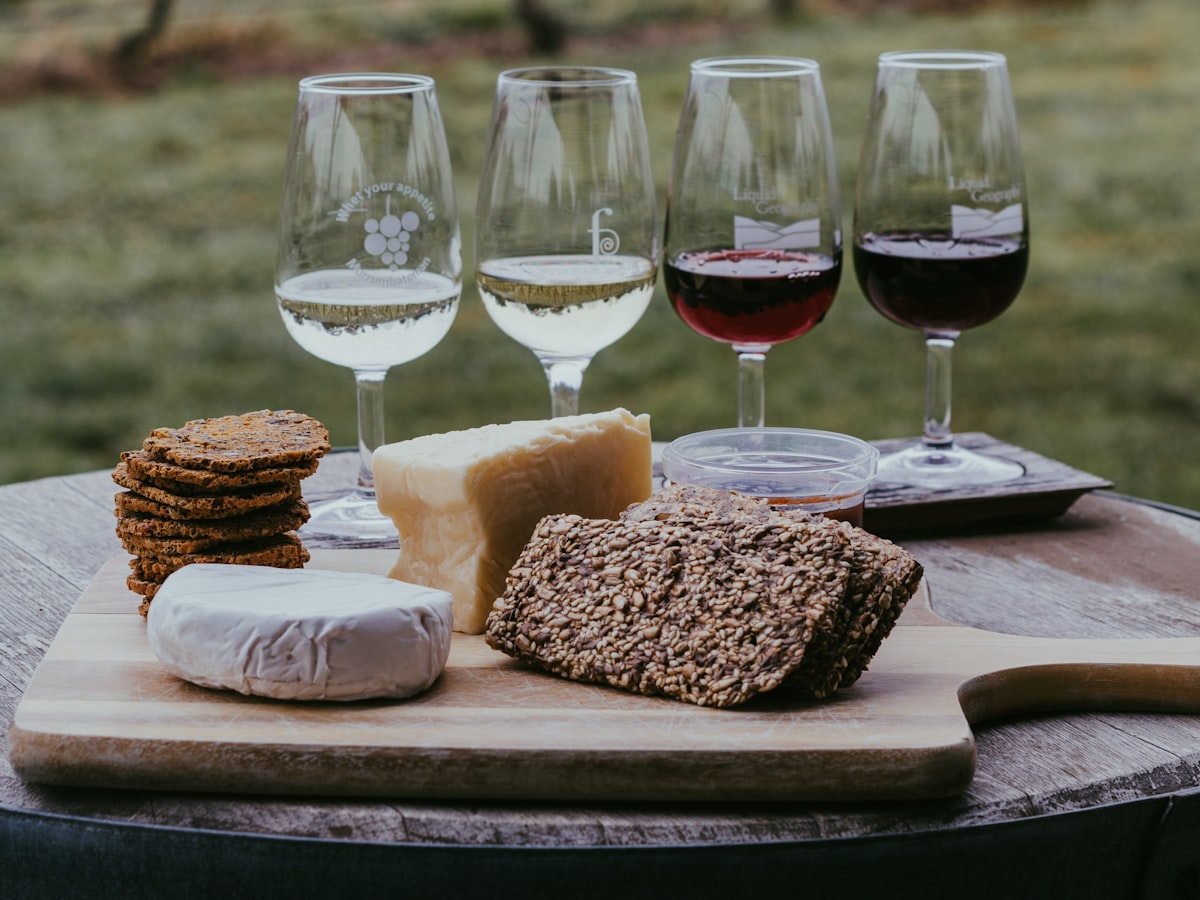 Verkostungsreihe mit mehreren Weingläsern, Käse und Brot auf einem Tisch