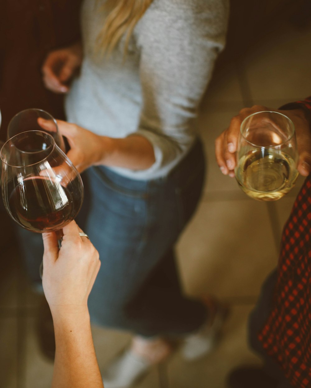 Zwei Frauen stoßen mit einem Glas Rot- und einem Glas Weißwein an
